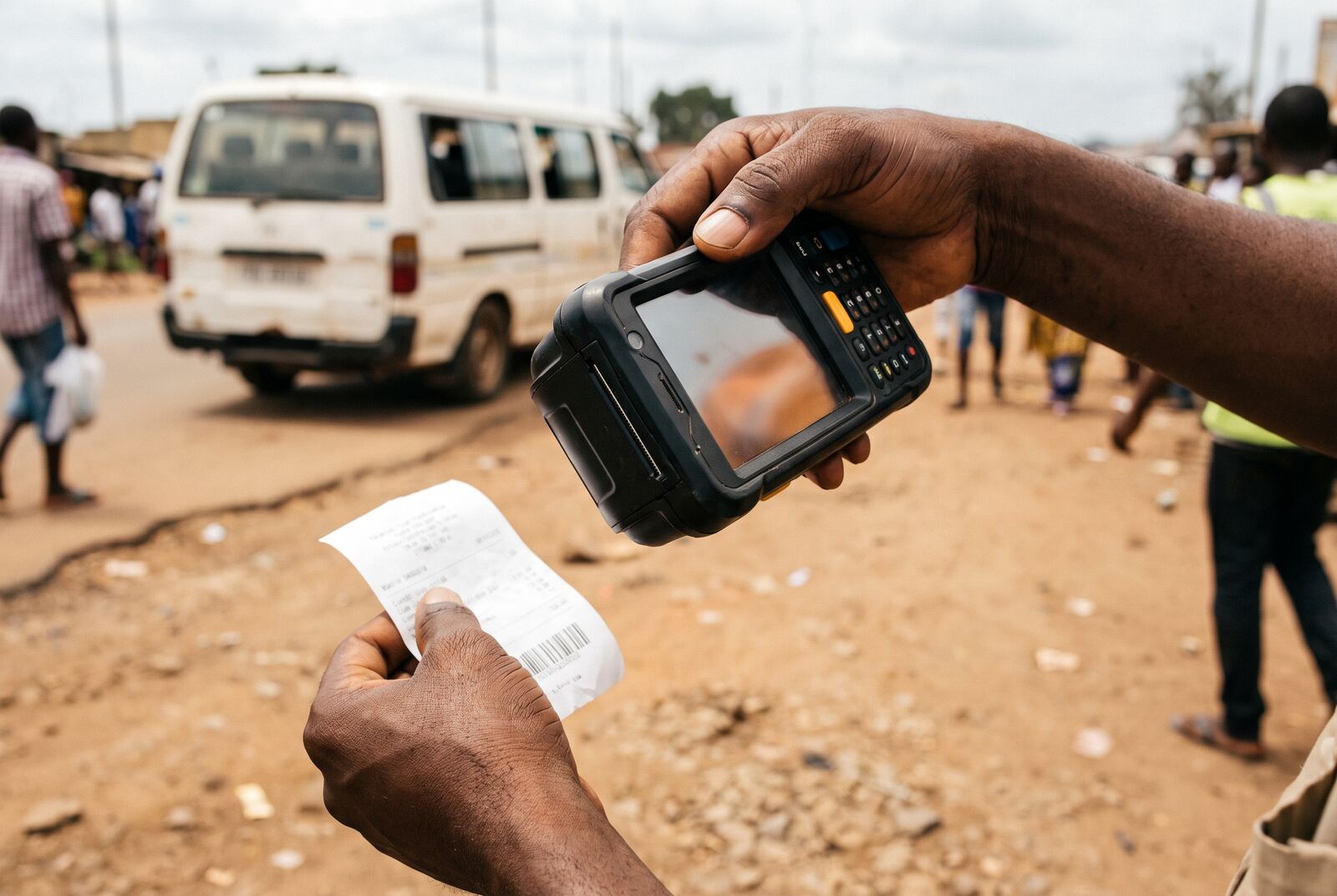 An inspector scanning the barcode on a paper receipt with a handheld device at the roadside